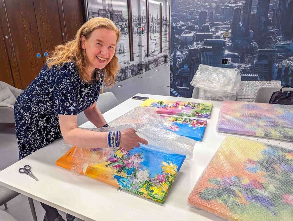 Wendy Foster unwrapping her commissioned paintings for the Magnolia Meeting Room